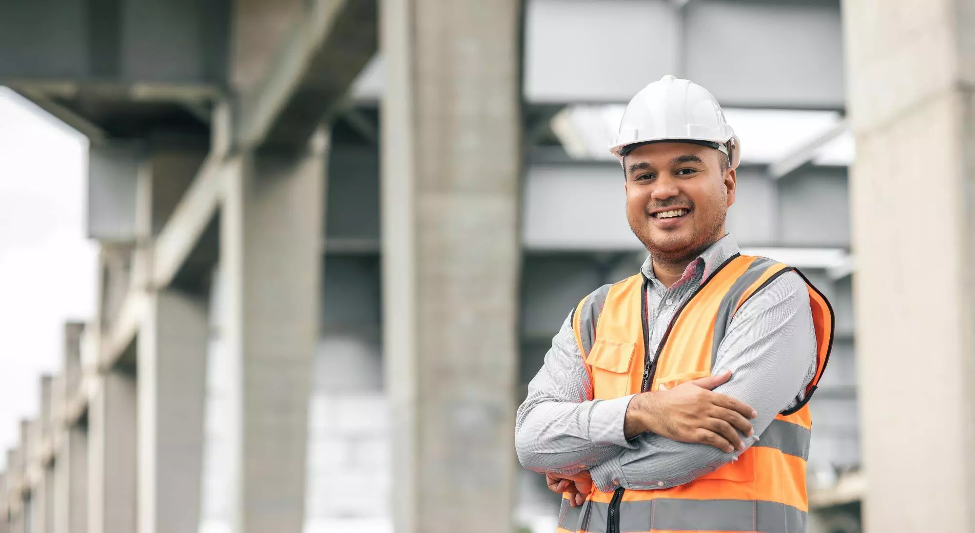 Smiling Man on Construction Site in hi-vis